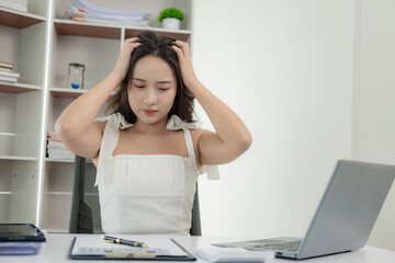Tired and overworked Asian woman suffers from eye strain, suffers from headaches Holding your head...