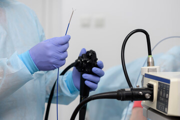 Endoscopic examination. Instruments for gastroscopy and colonoscopy close-up. The doctor holds a flexible endoscope and biopsy forceps in his hands. Endoscopy and minimally invasive surgery.