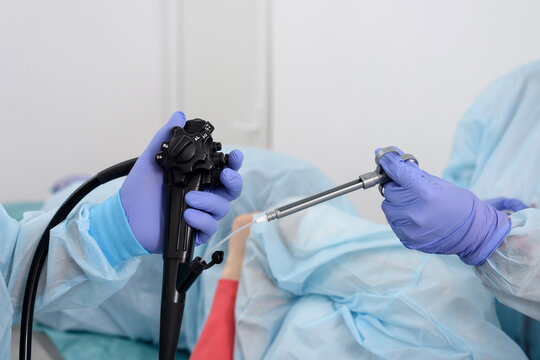 Endoscopic examination. Instruments for gastroscopy and colonoscopy close-up. Doctors are holding a flexible endoscope and biopsy forceps. Endoscopy and minimally invasive surgery in the hospital.