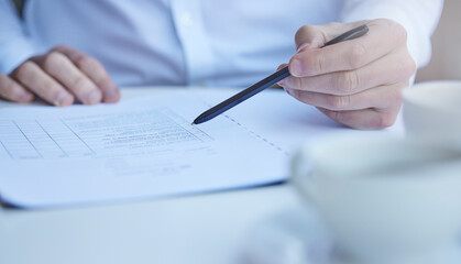 Hand, medical paperwork and pen at desk for information, report or history with planning for...
