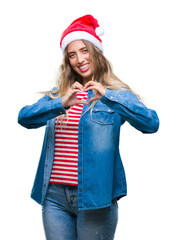 Beautiful young blonde woman wearing christmas hat over isolated background smiling in love showing heart symbol and shape with hands. Romantic concept.