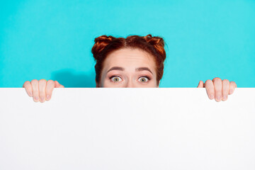 Photo of funky impressed lady hiding behind white placard empty space isolated blue color background