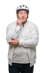 Handsome senior cyclist man wearing bike helmet over isolated background serious face thinking about question, very confused idea