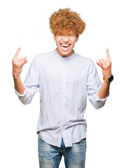 Young handsome business man with afro hair wearing elegant shirt shouting with crazy expression doing rock symbol with hands up. Music star. Heavy concept.