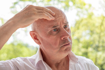 65-year-old eccentric man very surprised, senior showing grimaces, winks, mischievous grin,...