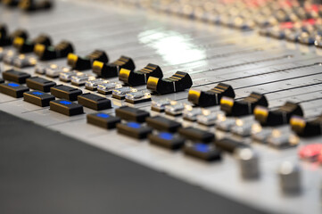 Close-up of sound mixing console with faders and knobs in a music studio