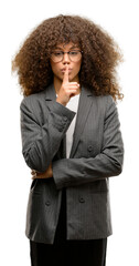 African american business woman wearing glasses asking to be quiet with finger on lips. Silence and secret concept.