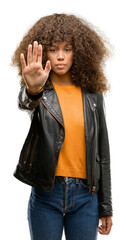African american woman wearing a leather jacket with open hand doing stop sign with serious and...