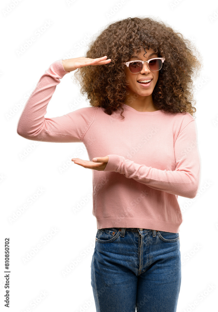 Sticker african american woman wearing pink sunglasses gesturing with hands showing big and large size sign,