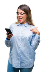 Young beautiful business woman texting message using smartphone over isolated background with surprise face pointing finger to himself