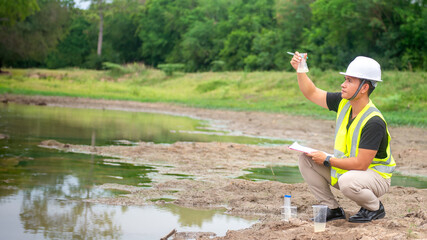 Environmental engineer Sit down next to a well and take a water sample to analysing check the...