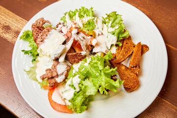 Salad with grilled veal, concasse tomatoes, olives, mixed salad and cheese sauce