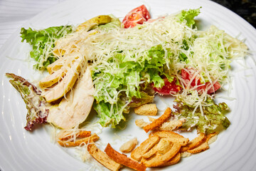 Salad with chicken breast, tomatoes, cheese, herbs and white bread croutons
