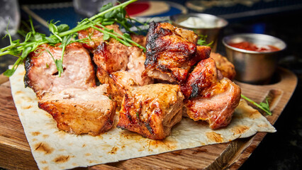 Pork shish kebab on pita bread with two types of sauces