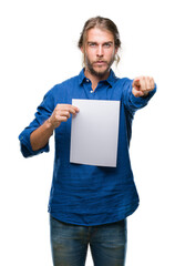 Young handsome man with long hair over isolated background holding blank paper pointing with finger to the camera and to you, hand sign, positive and confident gesture from the front