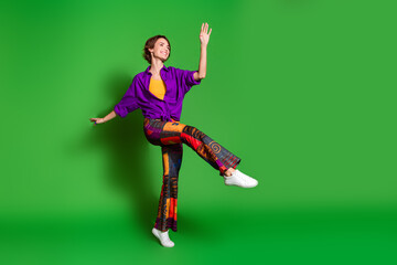 Photo of positive young woman in purple stylish shirt trendy vintage pants at discotheque isolated on green color background