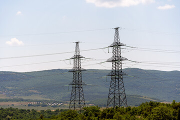 High voltage towers Electric pole. Power line support with wires for electricity transmission. High voltage grid tower with wire cable at distribution station. Energy industry, energy saving