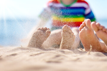 Happy children sitting on the sand beach in sunny day.