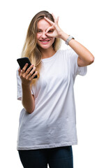 Young beautiful blonde woman using smartphone over isolated background with happy face smiling doing ok sign with hand on eye looking through fingers