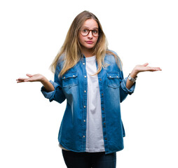 Young beautiful blonde woman wearing glasses over isolated background clueless and confused...