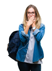 Young beautiful blonde student woman wearing headphones and glasses over isolated background shocked covering mouth with hands for mistake. Secret concept.