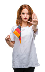 Young beautiful woman holding flag of germany over isolated background with open hand doing stop sign with serious and confident expression, defense gesture