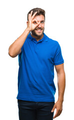 Obraz premium Young handsome man over isolated background doing ok gesture with hand smiling, eye looking through fingers with happy face.