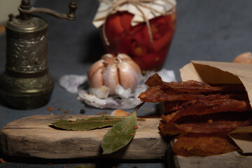 delicious jerky on a wooden background with garlic. products in beige color craft packaging. snack on alcohol. close up
