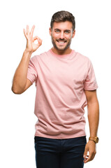 Naklejka premium Young handsome man over isolated background smiling positive doing ok sign with hand and fingers. Successful expression.