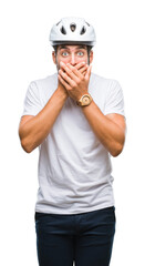 Young handsome man wearing cyclist safety helmet over isolated background shocked covering mouth with hands for mistake. Secret concept.