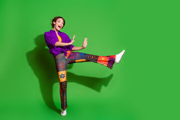 Photo portrait of funny young woman in purple stylish shirt dancing pushing arms empty space...