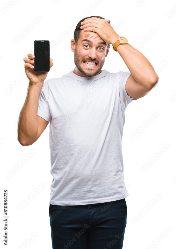 Sticker Young handsome man showing smartphone screen over isolated background stressed with hand on head, shocked with shame and surprise face, angry and frustrated. Fear and upset for mistake.