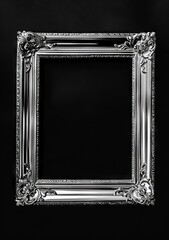 A silver frame with ornate details on a black background. - obrazy, fototapety, plakaty