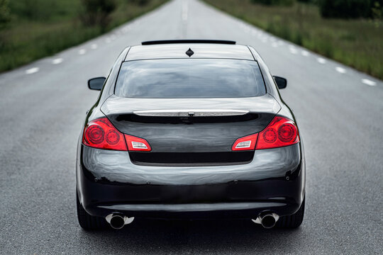 Black car driving down road