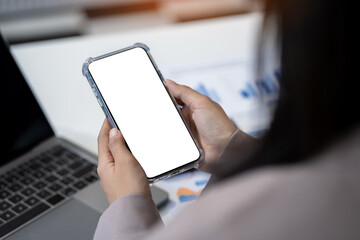 Business - technology and office concept - Hand holding mobile phone with blank screen in office.