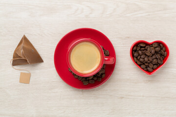 Cup of coffee made using pyramid on wooden background, top view