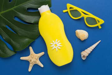 Sunscreen lotion with summer decor on color background, top view