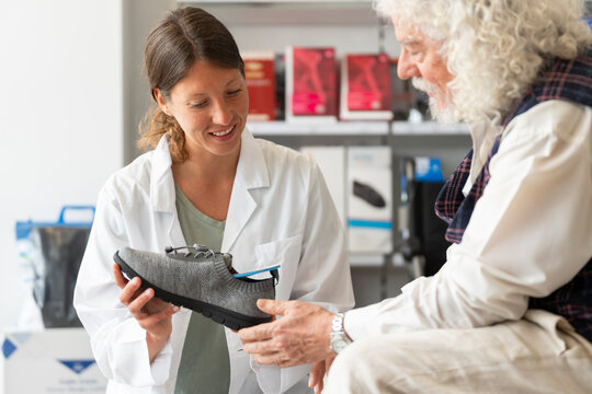 Senior man tries on an orthopedic boot at the pharmacy