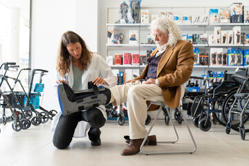 Senior man tries on an orthopedic boot at the pharmacy