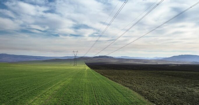 High-voltage power lines. Transmission of electricity by means of poles through agricultural land.