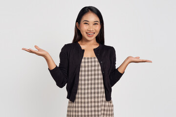 Excited young Asian woman wearing casual shirt presenting copy space with open palm gesture isolated on white background. People lifestyle concept