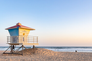 Overview of Beach, Pastel Color Sky Near Sunset with Lifeguard Tower in Midground, Waves and Clear Sky in Background, California, USA, horizontal, distant people