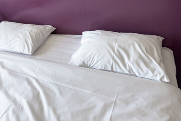 Obraz premium Freshly made bed with white linen in the hotel. Comfortable stay.