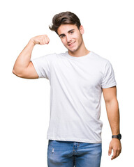 Young handsome man wearing white t-shirt over isolated background Strong person showing arm muscle, confident and proud of power