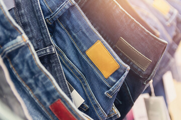 Many jeans hanging on arack. Row of pants denim jeans hanging in closet