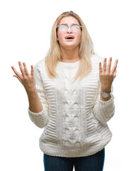 Fototapeta premium Young caucasian woman wearing glasses over isolated background crazy and mad shouting and yelling with aggressive expression and arms raised. Frustration concept.
