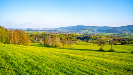 A breathtaking view of the Jested Ridge horizon, captured from a lush green field under a clear...
