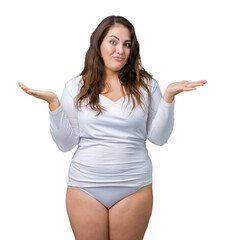 Beautiful plus size young overwight woman wearing white underwear over isolated background clueless and confused expression with arms and hands raised. Doubt concept.