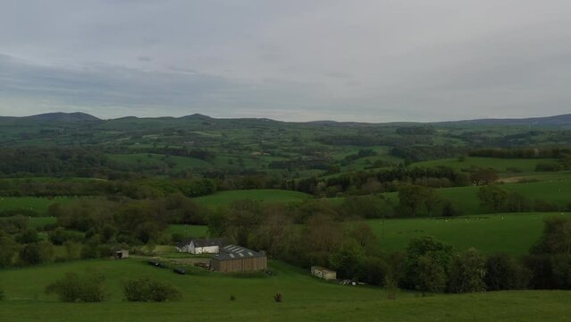 Aerial view of farm fields with hedge rows and trees landscape of England and Wales taken from drone UK 4K