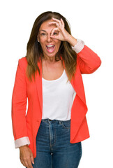 Beautiful middle age business adult woman over isolated background doing ok gesture with hand smiling, eye looking through fingers with happy face.